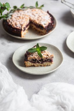 Siyah üzümlü yuvarlak turta ve masada bir tabakta nane şekeri. Tatlı.