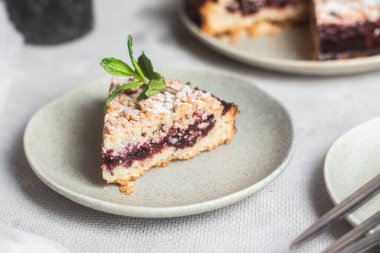Siyah üzümlü yuvarlak turta ve masada bir tabakta nane şekeri. Tatlı.