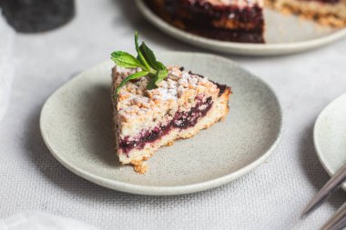 Siyah üzümlü yuvarlak turta ve masada bir tabakta nane şekeri. Tatlı.