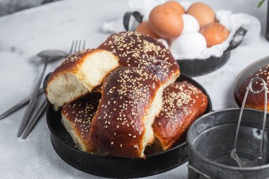 Masadaki tabakta yumurta ve susam tohumlu fırında turtalar. Maya turtaları.