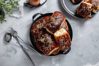 Masadaki tabakta yumurta ve susam tohumlu fırında turtalar. Maya turtaları.
