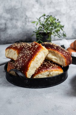 Masadaki tabakta yumurta ve susam tohumlu fırında turtalar. Maya turtaları.