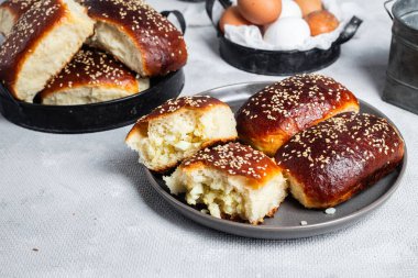 Masadaki tabakta yumurta ve susam tohumlu fırında turtalar. Maya turtaları.