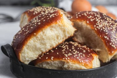 Masadaki tabakta yumurta ve susam tohumlu fırında turtalar. Maya turtaları.