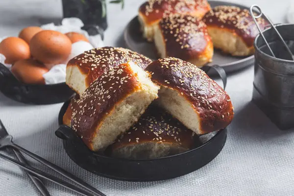 Masadaki tabakta yumurta ve susam tohumlu fırında turtalar. Maya turtaları.