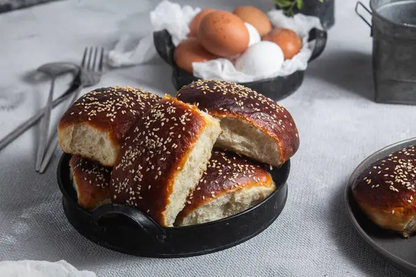 Masadaki tabakta yumurta ve susam tohumlu fırında turtalar. Maya turtaları.
