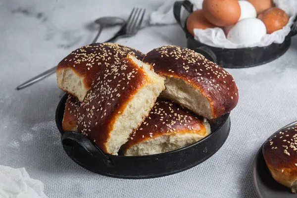 Masadaki tabakta yumurta ve susam tohumlu fırında turtalar. Maya turtaları.