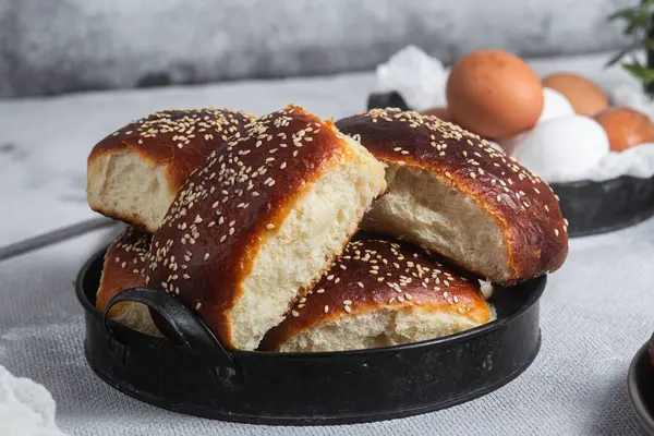 Masadaki tabakta yumurta ve susam tohumlu fırında turtalar. Maya turtaları.