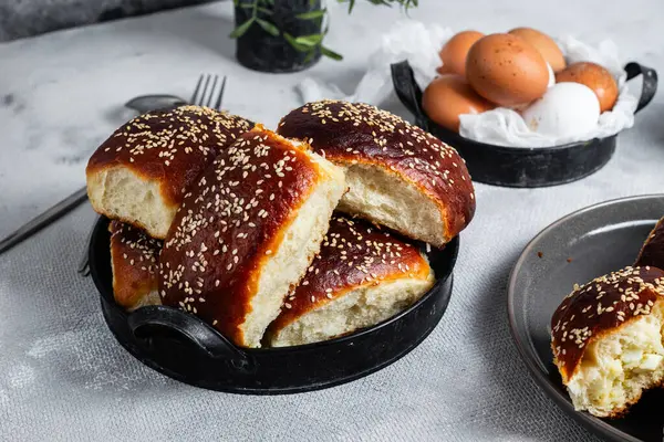 Masadaki tabakta yumurta ve susam tohumlu fırında turtalar. Maya turtaları.