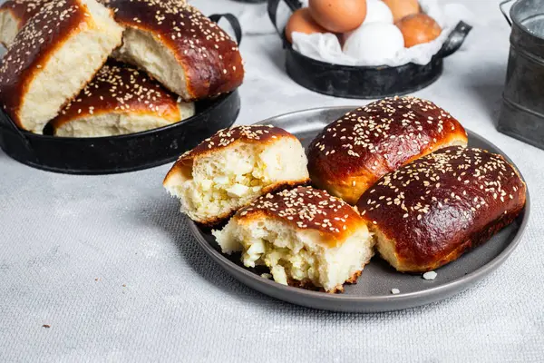 Masadaki tabakta yumurta ve susam tohumlu fırında turtalar. Maya turtaları.