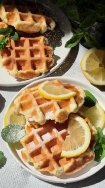 Masadaki beyaz tabakta naneli ve limonlu süzme peynirden yapılmış Belçika waffleları. Sağlıklı kahvaltı.