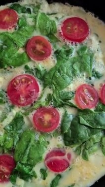 Fırında tavada ıspanaklı ve kiraz domatesli omlet pişirmek.