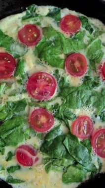 Fırında tavada ıspanaklı ve kiraz domatesli omlet pişirmek.