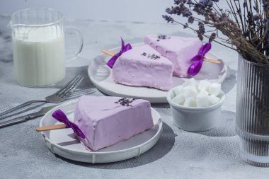 Masadaki beyaz tabakta peynirli kek. Cilalı cheesecake. Tatlı.