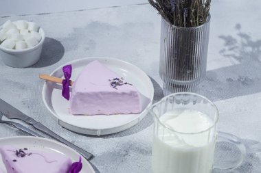 Masadaki beyaz tabakta peynirli kek. Cilalı cheesecake. Tatlı.