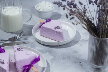 Masadaki beyaz tabakta peynirli kek. Cilalı cheesecake. Tatlı.