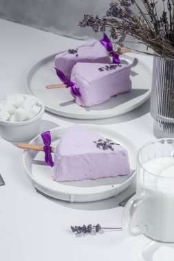 Masadaki beyaz tabakta peynirli kek. Cilalı cheesecake. Tatlı.