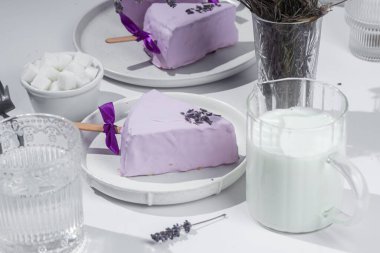 Masadaki beyaz tabakta peynirli kek. Cilalı cheesecake. Tatlı.