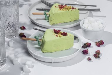 Masadaki beyaz tabakta peynirli kek. Cilalı cheesecake. Tatlı.