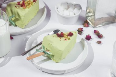 Masadaki beyaz tabakta peynirli kek. Cilalı cheesecake. Tatlı.