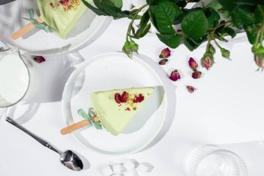 Masadaki beyaz tabakta peynirli kek. Cilalı cheesecake. Tatlı.