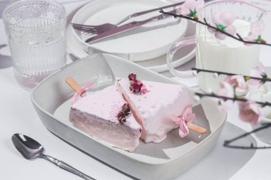 Masadaki beyaz tabakta peynirli kek. Cilalı cheesecake. Tatlı.