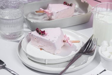 Masadaki beyaz tabakta peynirli kek. Cilalı cheesecake. Tatlı.