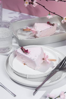 Masadaki beyaz tabakta peynirli kek. Cilalı cheesecake. Tatlı.