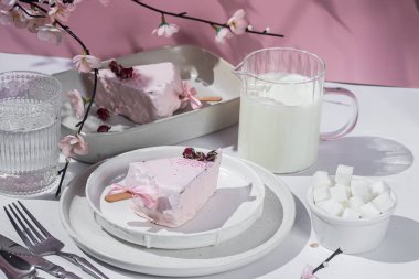 Masadaki beyaz tabakta peynirli kek. Cilalı cheesecake. Tatlı.