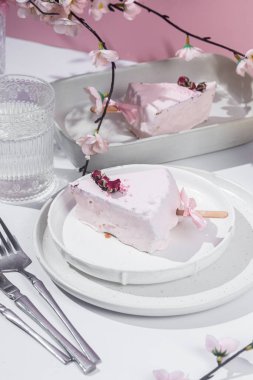 Masadaki beyaz tabakta peynirli kek. Cilalı cheesecake. Tatlı.