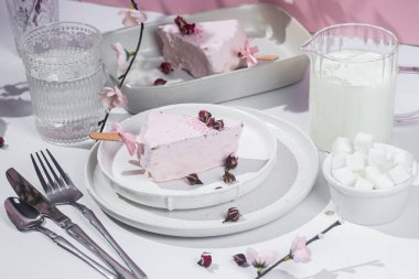 Masadaki beyaz tabakta peynirli kek. Cilalı cheesecake. Tatlı.