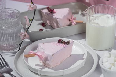 Masadaki beyaz tabakta peynirli kek. Cilalı cheesecake. Tatlı.