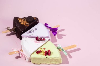 Masadaki beyaz tabakta çubuk üzerinde cheesecake. Cilalı cheesecake. Tatlı.