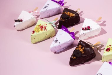 Masadaki beyaz tabakta çubuk üzerinde cheesecake. Cilalı cheesecake. Tatlı.