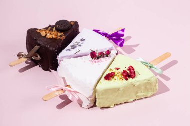 Masadaki beyaz tabakta çubuk üzerinde cheesecake. Cilalı cheesecake. Tatlı.