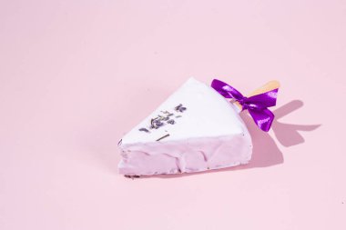 Masadaki beyaz tabakta çubuk üzerinde cheesecake. Cilalı cheesecake. Tatlı.