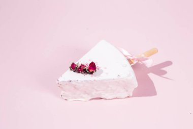 Masadaki beyaz tabakta çubuk üzerinde cheesecake. Cilalı cheesecake. Tatlı.