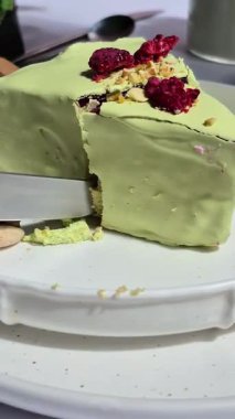 Masadaki beyaz tabakta çubuk üzerinde cheesecake. Cilalı cheesecake. Tatlı.