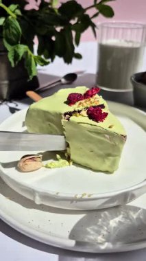 Masadaki beyaz tabakta çubuk üzerinde cheesecake. Cilalı cheesecake. Tatlı.