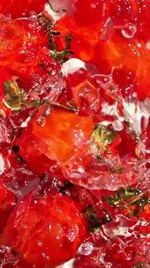 Suda hareketli kiraz domatesleri açık arkaplanda yakın plan