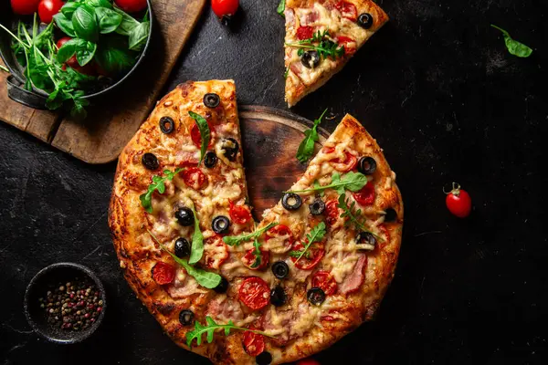 Jambonlu, domatesli ve peynirli iştah açıcı pizza. İnce pizza.