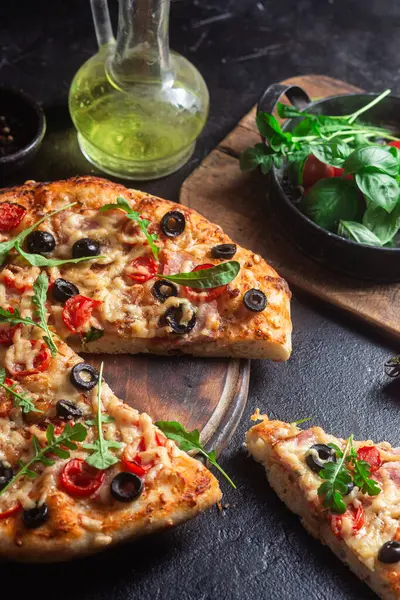 Jambonlu, domatesli ve peynirli iştah açıcı pizza. İnce pizza.