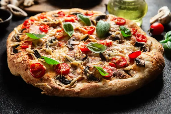 Jambonlu, domatesli ve peynirli iştah açıcı pizza. İnce pizza.