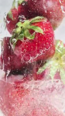 Yakından bakınca köpüklü suda olgun çilekler. Su ve çilek kabarcıkları