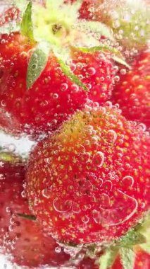 Yakından bakınca köpüklü suda olgun çilekler. Su ve çilek kabarcıkları