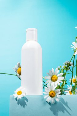 Papatya çiçekli beyaz bir şişe cilt bakımı.