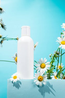 Papatya çiçekli beyaz bir şişe cilt bakımı.
