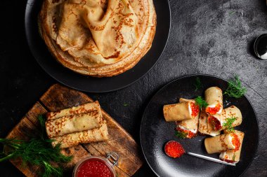 Masadaki siyah tabakta kırmızı havyarla nefis bir blini. İnce krepler. Karnaval