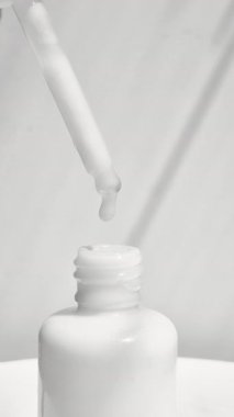 Yakından pipetten damlayan yüz serumu. Şişede pipetli yüz için bir damla serum Milk Serum.