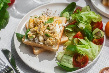 Yağda yumurtalı ekmek, salatalık, domates ve otla birlikte. Beyaz arka plan. Sağlıklı kahvaltı.